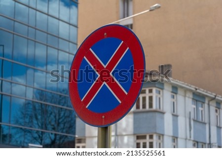 Red cross and blue round sign. Metal stop prohibited traffic sign. It is forbidden to stop on the road.
