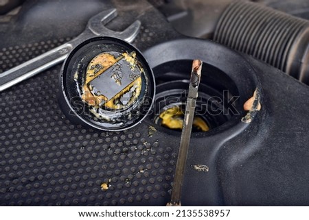 The thick, greasy yellow motor oil under oil cap as signs and symptom of a blown head gasket. Broken a car Royalty-Free Stock Photo #2135538957