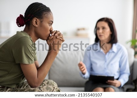 Upset Pensive Black Military Lady Having Therapy Session With Psychologist In Office, African American Soldier Woman Suffering Mental Illness Or Posttraumatic Stress Disorder, Selective Focus Royalty-Free Stock Photo #2135540107
