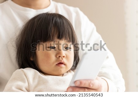 A baby looking at a smartphone (1 year and 8 months old, girl, Japanese) and a mother's hand showing it (30s, Japanese)
