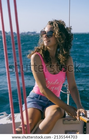 Beautiful girl in a pink swimsuit on a yacht in the sea. Bachelorette party on a yacht.
