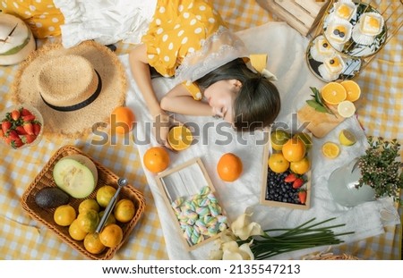 a girl having a picnic in an orange plantation.