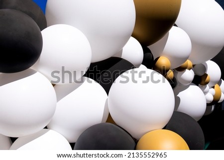 Cluster of white, black and golden balloons.