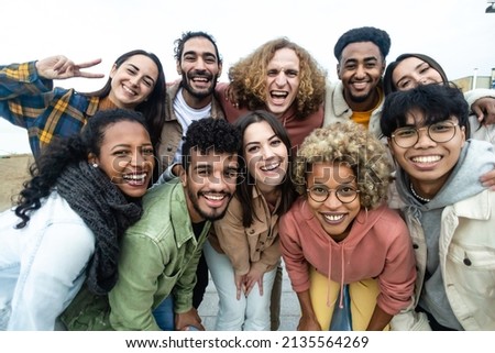 Happy group of multiethnic young friends - Diverse people smiling at camera outdoors - Community and unity people concept Royalty-Free Stock Photo #2135564269