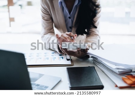 Business woman hand holding pencil looking at bank savings account document. account or saving money or insurance concept.