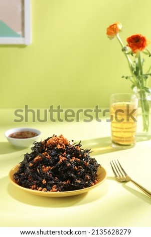 Seaweed snack decorated with water flower and fork in yellow table for food advertising 