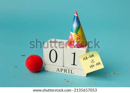 April 1st. Image of april 1 wooden calendar and festive decor on the blue background. April Fool's Day. Royalty-Free Stock Photo #2135657053