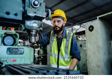 Male factory mechanics or Engineer in safety uniforms are working on metal drilling machines in industrial production lines, steel processing industry, mechanical maintenance. Royalty-Free Stock Photo #2135660733