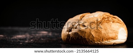 Fresh fragrant bread on the table. On a black background. High quality photo