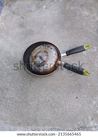 picture of two pan with become rusty in the back, because always used, put on the floor on sunny day 