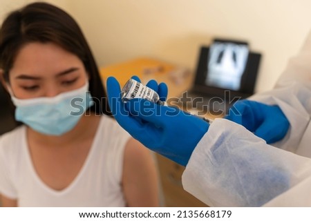 Female doctor holds syringe and bottle with vaccine for coronavirus cure. Concept of corona virus treatment, injection, shot and clinical trial during pandemic.OMICRON
