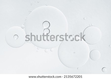 Abstract oil bubbles background. Cosmetic liquid beauty product. Face serum texture. Royalty-Free Stock Photo #2135672201
