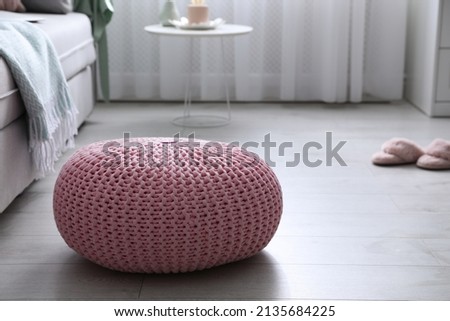 Pink knitted pouf near sofa in living room. Space for text Royalty-Free Stock Photo #2135684225
