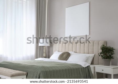 Blank canvas on wall in stylish bedroom interior. Space for design