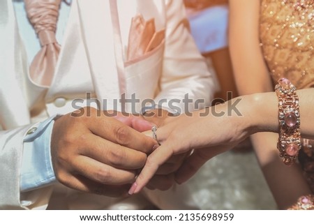 hand of a man wearing a wedding ring to his bride