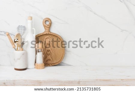 Kitchen utensils on table with marble wall and copy space Royalty-Free Stock Photo #2135731805