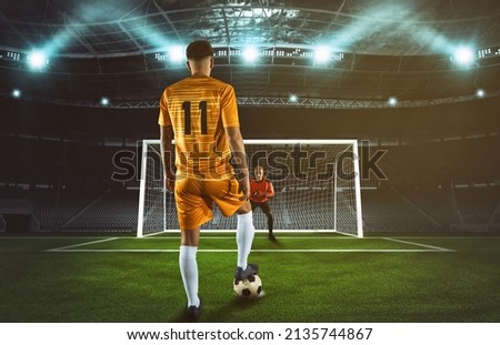 Soccer scene at night match with player in yellow uniform kicking the penalty kick Royalty-Free Stock Photo #2135744867