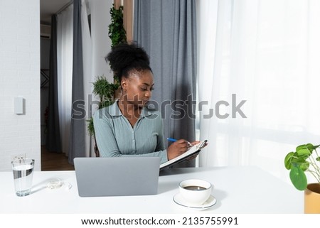Young concentrated African American woman blogger and human rights activist writing a blog about cyber bullying and racism among young people through her personal negative experience. Royalty-Free Stock Photo #2135755991