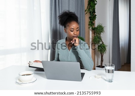 Young concentrated African American woman blogger and human rights activist writing a blog about cyber bullying and racism among young people through her personal negative experience. Royalty-Free Stock Photo #2135755993
