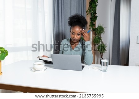 Young concentrated African American woman blogger and human rights activist writing a blog about cyber bullying and racism among young people through her personal negative experience. Royalty-Free Stock Photo #2135755995