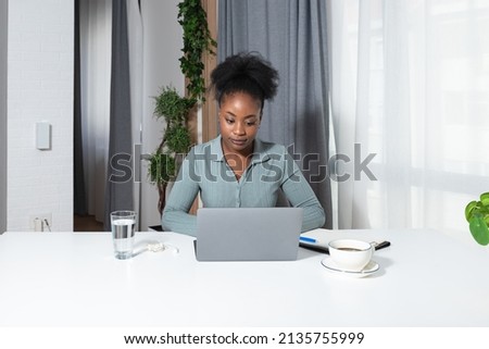 Young concentrated African American woman blogger and human rights activist writing a blog about cyber bullying and racism among young people through her personal negative experience. Royalty-Free Stock Photo #2135755999