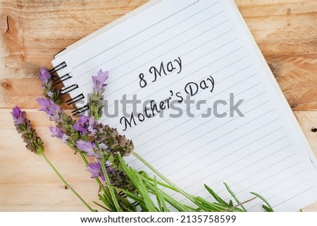 8 May Mother’s Day handwritten on notepad on rustic style surface