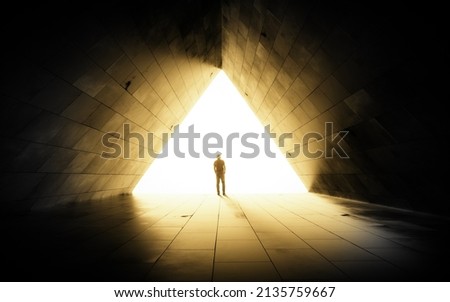The figure of a man in a tunnel , background of bright light. Royalty-Free Stock Photo #2135759667