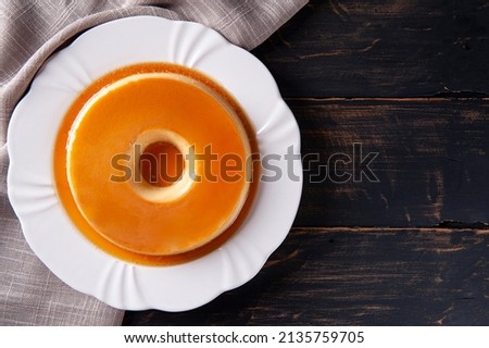 Delicious condensed milk pudding on white plate. Top view. Copy space. Royalty-Free Stock Photo #2135759705