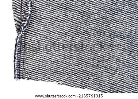 Piece of black jeans fabric isolated on white background. Rough uneven edges. Back side of fabric