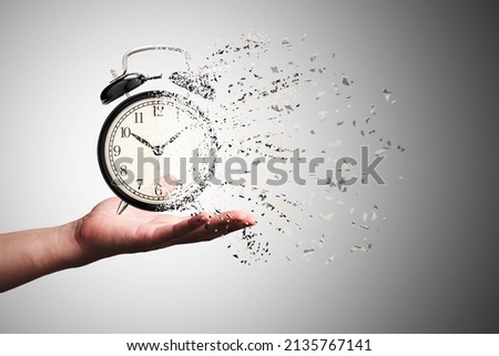 Retro black alarm clock dissolving into a little particles for time can not return and never wait anyone , Time management concept. Royalty-Free Stock Photo #2135767141