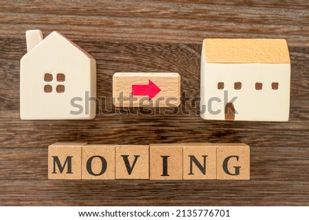 Concept of moving (Miniature house and the word “MOVING”)