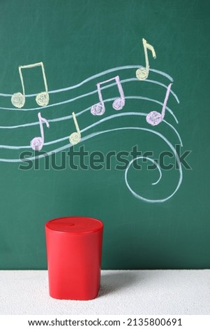 Wireless portable speaker and drawing of music notes on color background