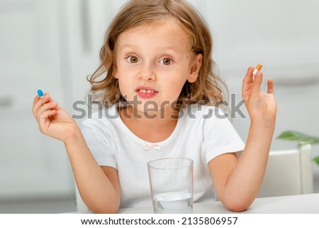 the child shows the capsule, takes medications or vitamin, Biologically active food supplement in the child's diet Royalty-Free Stock Photo #2135806957