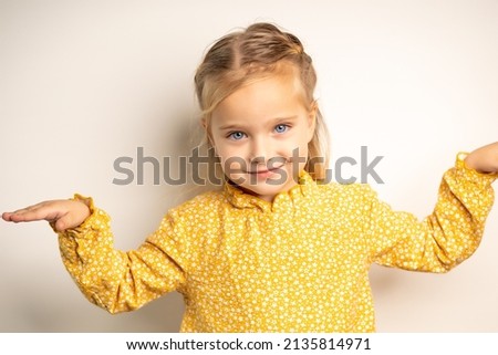 A little blue-eyed girl depicts a flying plane. The girl is dancing in front of the camera.