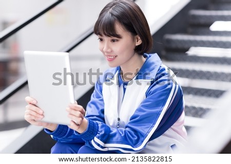 chinese female student using a tablet on campus