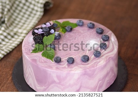 Delicious mousse cake with summer berries and mirror glaze