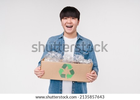 Happy eco-friendly asian korean activist holding a box full of plastic bottles for recycling. Environmental protection, Earth day concept