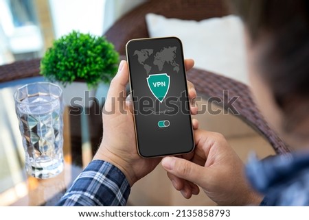 male hand holding phone with app vpn creation Internet protocols for protection private network  Royalty-Free Stock Photo #2135858793