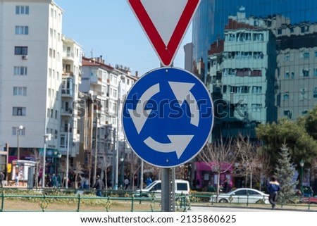 Blue roundabout traffic sign. Round road where vehicles turn.