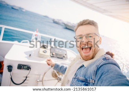 Young man yacht driver takes selfie photo, concept of trip maldives or egypt by boat travel summer.