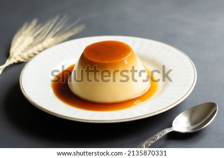 Cream caramel pudding with caramel sauce in plate on rustic table Royalty-Free Stock Photo #2135870331