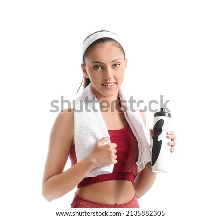 Sporty teenage girl with towel and bottle of water on white background