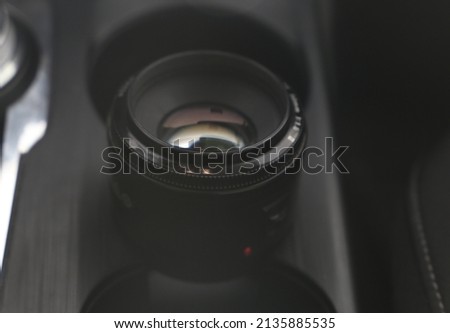 camera lens standing on black background