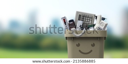 Recycling bin full of electronic waste, smiling cute character Royalty-Free Stock Photo #2135886885