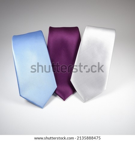 polyester fabric neckties for men formal wear triple color's with white background, male classic plain pattern neckties layered on plain backdrop   Royalty-Free Stock Photo #2135888475