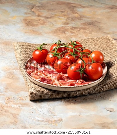Plate with prosciutto parma and tomatoes on a sack, rustic table, italian breakfast, stock photo