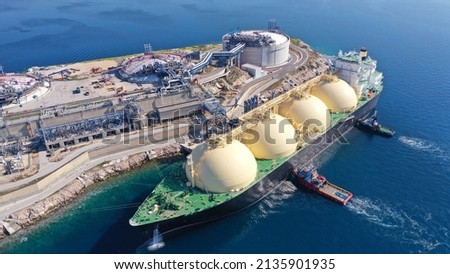 Aerial drone photo of LNG (Liquified Natural Gas) tanker anchored in small gas terminal island with tanks for storage Royalty-Free Stock Photo #2135901935