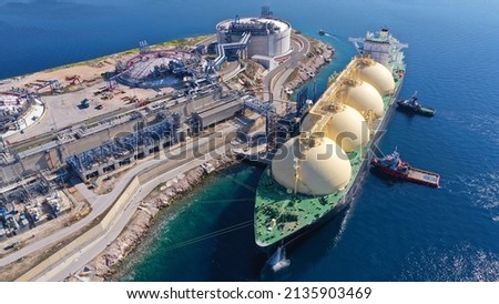 Aerial drone photo of LNG (Liquified Natural Gas) tanker anchored in small LNG industrial islet of Revithoussa equipped with tanks for storage, Salamina, Greece Royalty-Free Stock Photo #2135903469