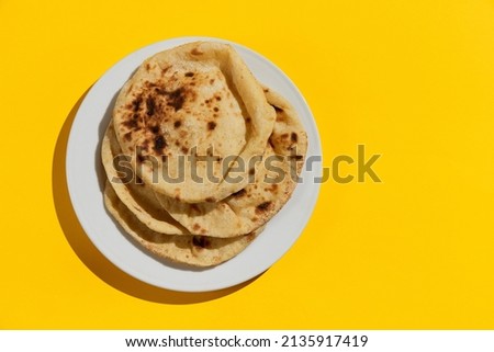 Egyptian bread Aish Baladi on. A lot of fresh bread lies on the yellow table Royalty-Free Stock Photo #2135917419