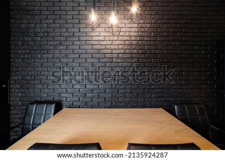stylish designer black kitchen with brick wall and black chairs